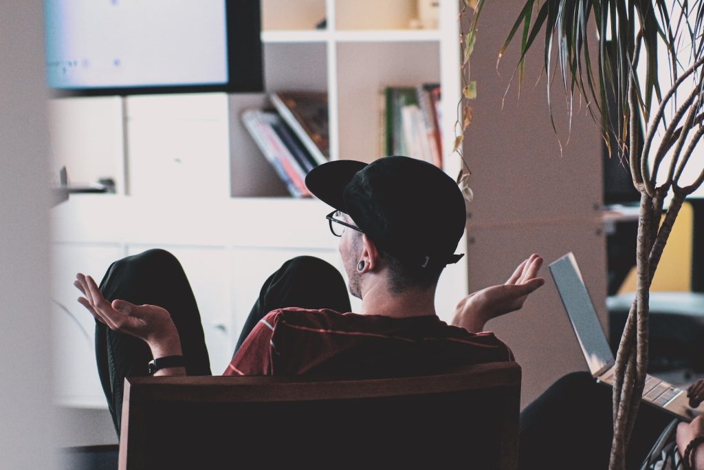 man in black shirt and black hat sitting on black chair